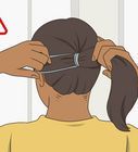 a woman is cutting her hair with scissors