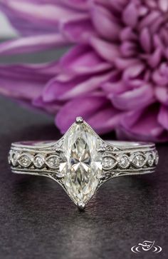 a close up of a ring with a flower in the background