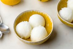 three bowls filled with sugar and lemons on top of a white table next to silverware