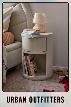 a white night stand with books on it and the words urban outfitters above it