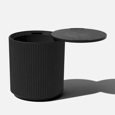 two black vases sitting next to each other on a white surface, one is empty