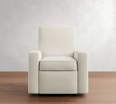 a white recliner sitting on top of a wooden floor next to a gray wall