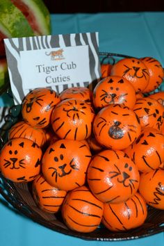 there are many orange balls with faces painted on them in the shape of tiger cats