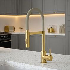 a kitchen with an oven, sink and counter top in gold colored metal fixtures is shown