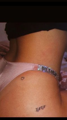 a woman's stomach with the word love tattooed on it