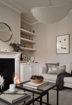 a living room filled with furniture and a fire place in front of a white fireplace