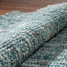 a close up view of a blue and white rug on a wooden floor with wood floors in the background