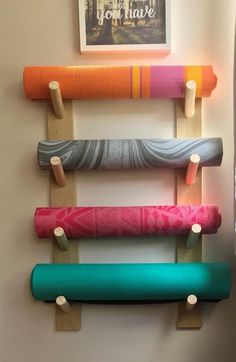 a wall mounted rack with yoga mats on it