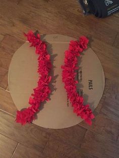 two pieces of cardboard with red flowers on it sitting on the floor next to a suitcase