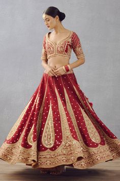 Bright red gota embroidered lehenga with scallop border and floral motifs in raw silk. Paired with gota embroidered blouse and golden thread embroidered sheer dupatta finished with fringes.
Component: 3
Pattern: Embroidered
Type Of Work: Dori, Adda
Neckline: Leaf
Sleeve Type: Half
Fabric: Lehenga and Blouse: Raw Silk, Dupatta: Butterfly Net
Color: Red
Other Details: 
Sheer dupatta
Tassel detail
Gota work blouse
Occasion: Bride,Wedding - Aza Fashions Red Sharara With Intricate Embroidery, Red Kundan Gown With Traditional Drape, Red Lehenga With Resham Embroidery And Traditional Drape, Festive Red Lehenga With Dori Work, Red Embroidered Floor-length Choli, Red Floor-length Lehenga With Dori Work, Red Semi-stitched Kundan Gown, Red Lehenga With Dori Work For Reception, Red Floor-length Lehenga For Traditional Ceremonies