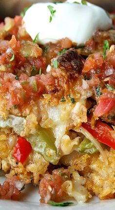 a close up of a plate of food with vegetables and sour cream on the top