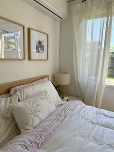 a bed with two pictures hanging on the wall above it