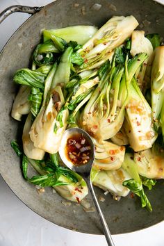 a bowl filled with vegetables and sauce on top of a table