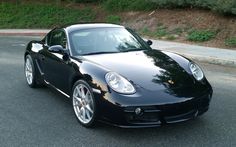 a black sports car is parked on the street