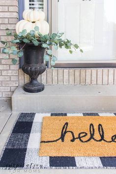 a welcome mat with the word hello written on it in front of a house door