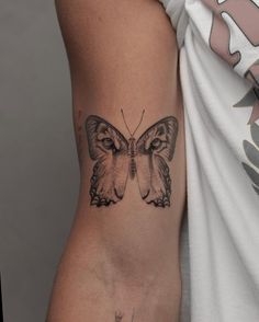 a woman's arm with a butterfly tattoo on the left side of her body