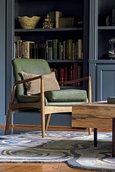 a green chair sitting in front of a book shelf