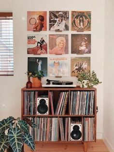 a record player is sitting on top of a shelf in front of a wall full of records