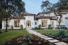 a white house with lots of windows and landscaping