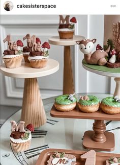 three tiered trays with cupcakes and cakes on them, one is decorated with woodland animals