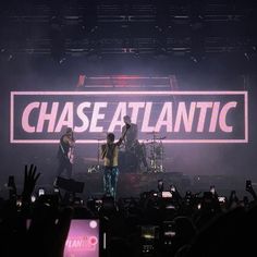 the band chase atlantic performing on stage with their hands up in front of an audience