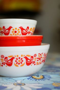 three red and white bowls sitting on top of a table