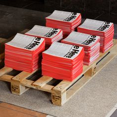 stacks of red and white boxes sitting on top of wooden pallets