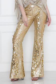 Gold disco trouser heavily embellished with sequins and pearls.
Component: 1
Pattern: Hand Embellished
Type Of Work: Sequins, Pearls
Fabric: Power Net
Color: Gold
Other Details: 
Side pockets
Attached lining
Approximate Product Weight: 3 kgs
Note: Top and bustier worn by the model is not for sale
Occasion: Party - Aza Fashions Glamorous Rhinestone Bottoms, Glamorous Rhinestone Party Bottoms, Elegant Rhinestone Party Bottoms, Glamorous Fitted Pants With Rhinestones, Glamorous Evening Pants With Rhinestones, Glamorous Embellished Bottoms For Evening, Embellished Trousers For Party, Glamorous Embellished Evening Pants, Glamorous Rhinestone Bottoms For Party Season