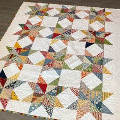 a multicolored star quilt on a wooden floor