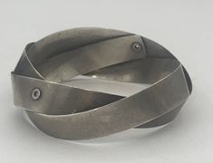 This is a very neat and unusual bracelet, it It's technically a bangle bracelet considering it goes all the way around but it looks a lot like a cuff. The bracelet is solid sterling silver and handmade. I do not see any markings but the bracelet has been tested and guaranteed to be sterling silver. It has a brutalist/modernist appearance to me. Very cool. Please see photos for approximate measurements. My wrist is a size 6 and it fits me perfectly. Adjustable Contemporary Bangle Bracelet, Handmade Adjustable Contemporary Bracelets, Adjustable Modernist Bangle Bracelet, Contemporary Handmade Adjustable Bracelets, Modernist Metal Cuff Bangle, Modernist Bangle Bracelet As Gift, Modernist Bangle Bracelet For Gift, Adjustable Modernist Sterling Silver Bracelet, Modernist Handmade Cuff Bangle Bracelet