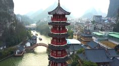 a tall red tower sitting next to a river