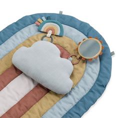 a baby's play mat with a cloud shaped pillow and toy rattler on it