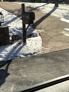 a mailbox sitting on the side of a road covered in snow