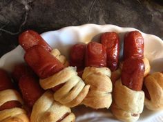 hotdogs and croissants on a plate with buns wrapped around them