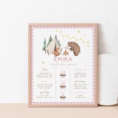 a baby shower sign with a bear and tent in the background on a shelf next to a cup