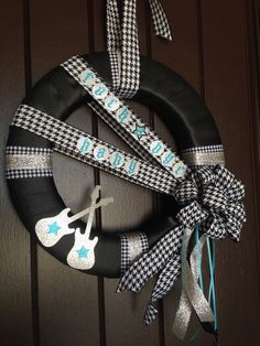 a black and white wreath with scissors on the front door, decorated with blue ribbon