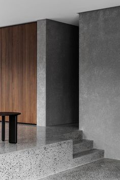 a bench sitting on top of some concrete steps next to a wooden wall and door