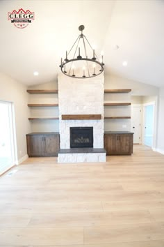 an empty living room with a fireplace and built in shelves