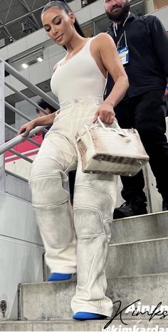 a woman in white is walking down some stairs