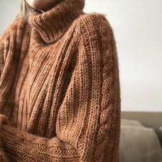 a woman in an orange sweater is posing for the camera