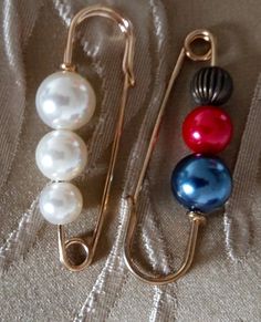 three different colored pearls are hanging from hooks