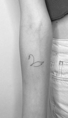 a woman's arm with a single line swan tattoo on the left inner arm