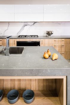 two pears are sitting on the counter top in this modern kitchen with stainless steel appliances