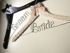 the bride and groom hangers are made out of paper with ribbon ties on them