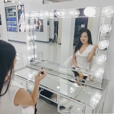 a woman is looking at herself in the mirror