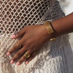 a close up of a person wearing gold rings