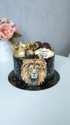 there is a cake decorated with a lion and crown on the table next to flowers