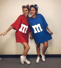 two women dressed in matching m and m t - shirts pose for a photo together