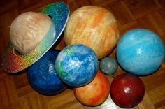 there are many different colored balls on the wooden floor with one ball in the middle