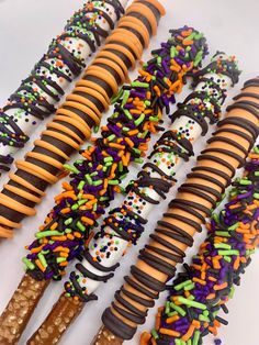 halloween sprinkles and pretzels are lined up on a white surface